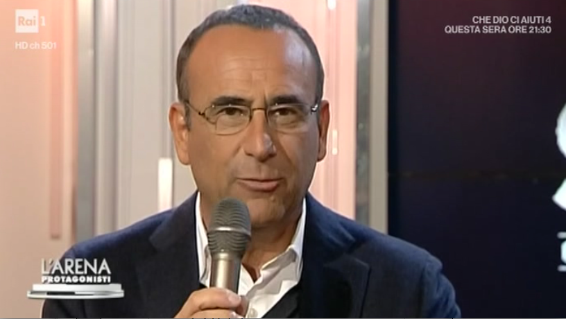Carlo Conti a L’Arena: “Maria a Sanremo? Non si siederà sui gradini. Con me come nei promo”