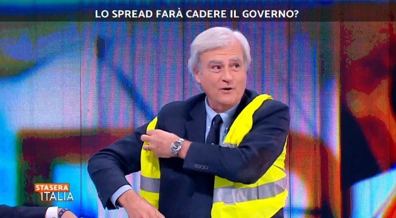 Stasera Italia, l’economista Rinaldi indossa il giubbino fosforescente. La Palombelli non gradisce: “Ha scherzato troppo”