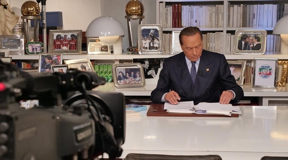 Berlusconi va in tv e le foto alle sue spalle cambiano posto in continuazione