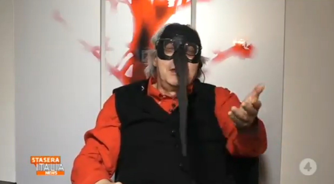 Stasera Italia, Sgarbi si presenta con la maschera anti-covid: “Ha il naso di un metro che ci distanzia”