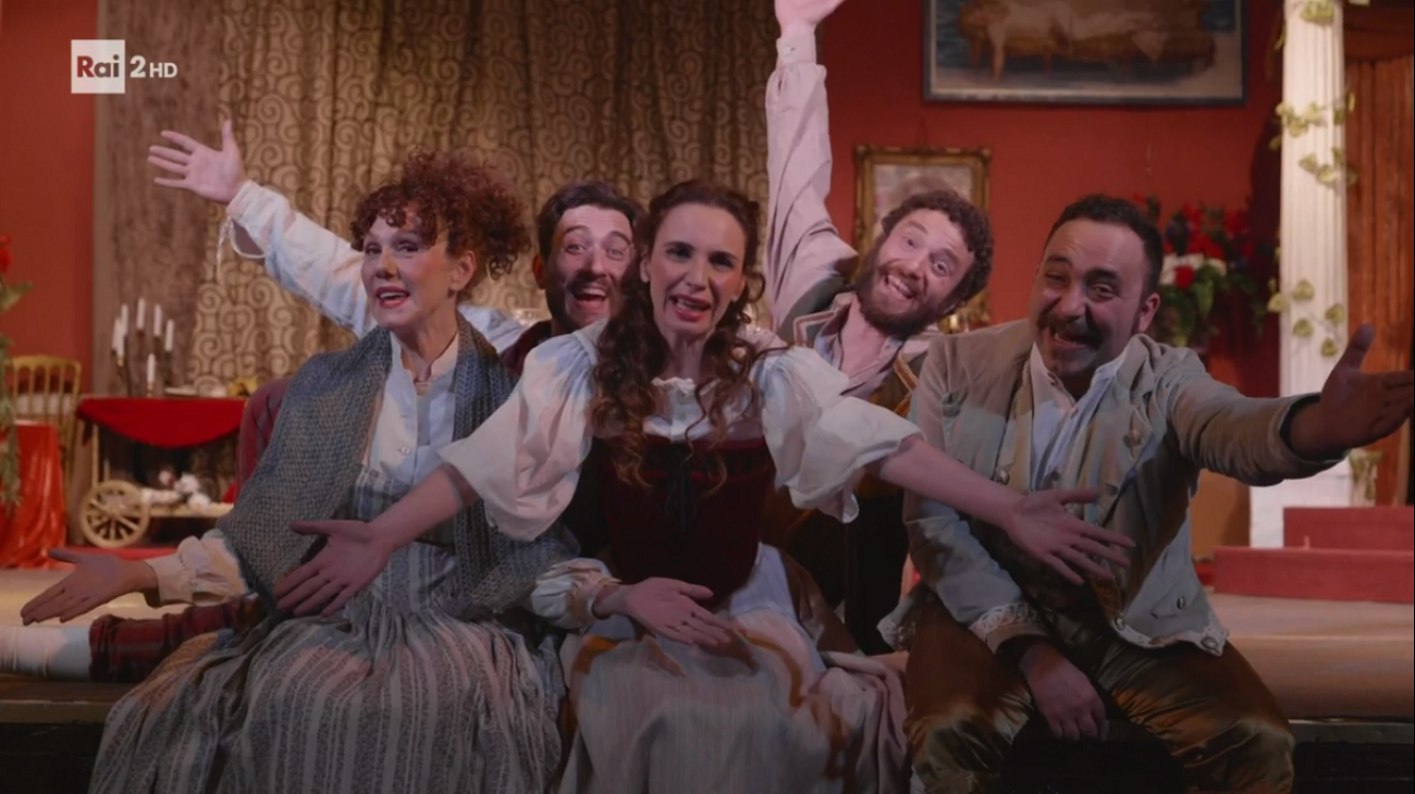 Una pezza di Lundini gioca ancora con la metatelevisione: parte la ricerca al nuovo jingle di Rai 2. Ma l’attrazione principale resta Emanuela Fanelli